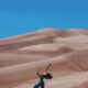 Iemand die in een woestijngebied een yogo-oefening doet.